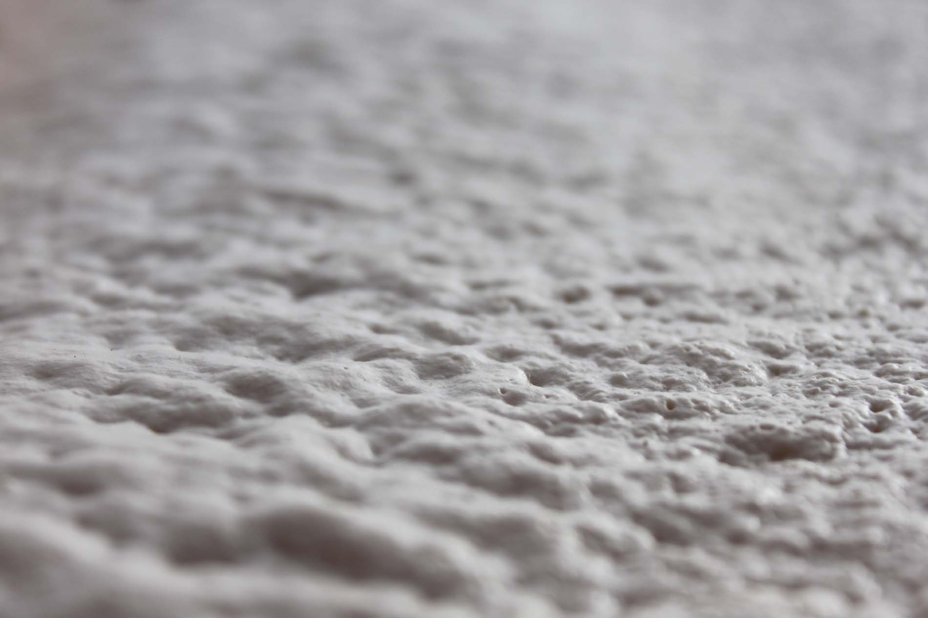 Close-up of the surface of polyurethane spray foam insulation shortly after installation