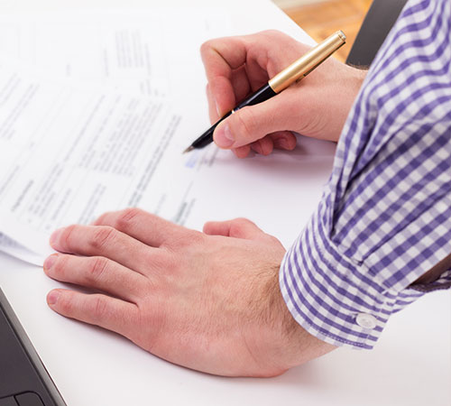 Man signing paperwork.