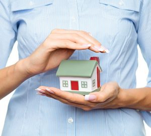 Person holding a small model of a house.