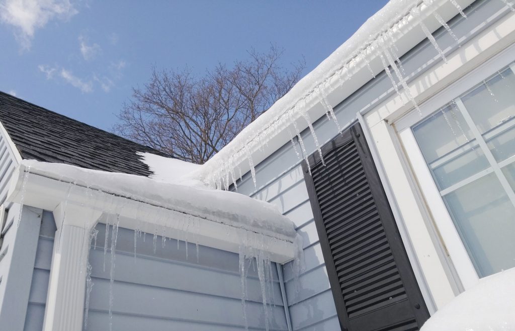 Icicles hanging from snow-covered roof.