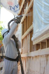 Worker spraying insulation.