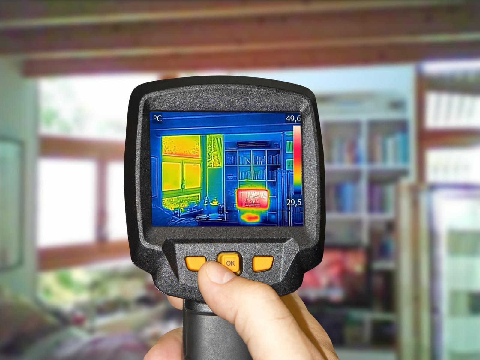 Professional performing home energy audit, scanning entire living room for air leaks and temperature differences, with thermal camera.