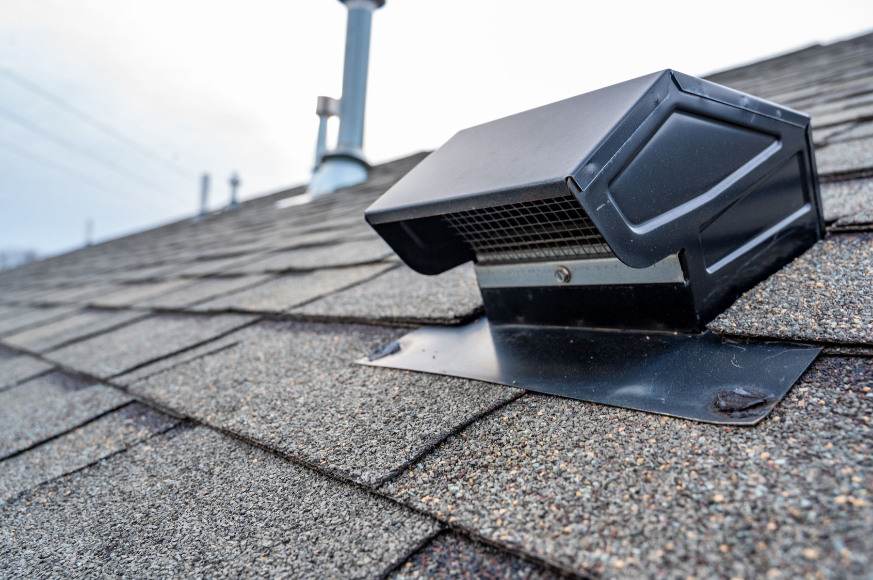 Static vent installed on a residential shingle roof for passive attic ventilation.